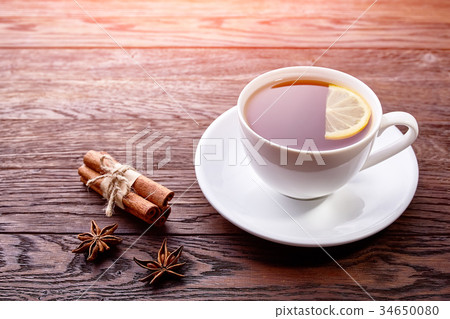 White porcelain cup of tea with cinnamon sticks White porcelain cup of tea with cinnamon sticks 34650080