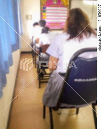 Blur students doing exam in classroom Blur students doing exam in classroom 34650097