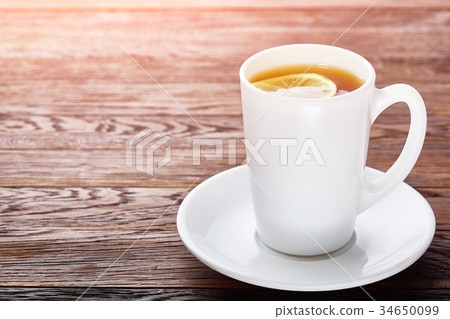 White porcelain cup of tea with cinnamon sticks White porcelain cup of tea with cinnamon sticks 34650099