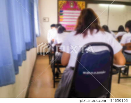 Blur students doing exam in classroom 34650103