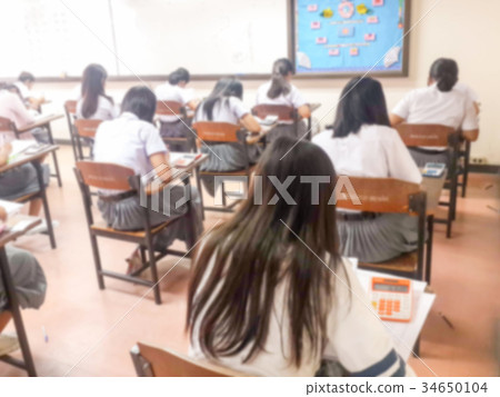 Blur students doing exam in classroom Blur students doing exam in classroom 34650104