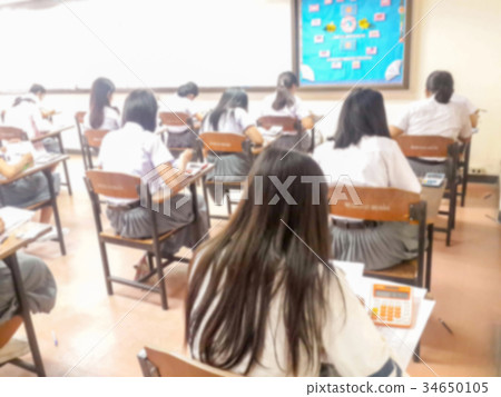 Blur students doing exam in classroom Blur students doing exam in classroom 34650105