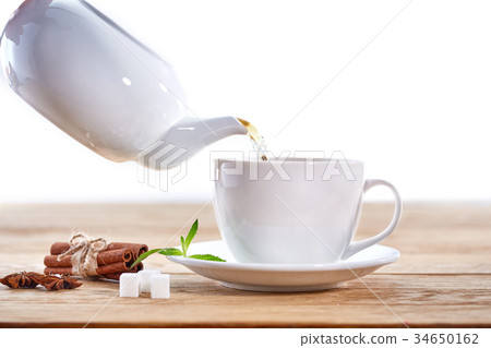 cup with green tea, sugar and teapot on light cup with green tea, sugar and teapot on light 34650162