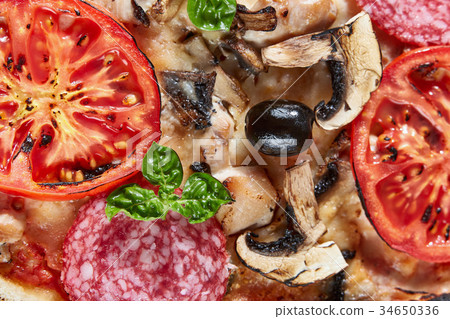 Closeup of pizza with salami, tomatoes and olives Closeup of pizza with salami, tomatoes and olives 34650336