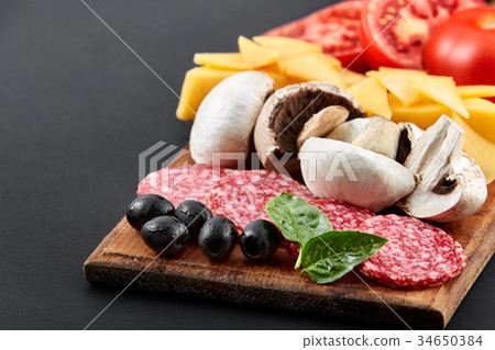 Delicious slices of pizza ingridients on a black Delicious slices of pizza ingridients on a black 34650384