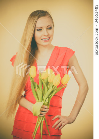 Pretty woman with yellow tulips bunch 34653485