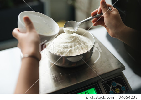 Bakery chef weighing flour on the digital scale 34654233