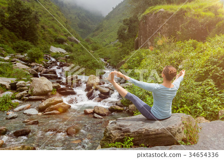 Woman doing Ashtanga Vinyasa Yoga asana outdoors 34654336