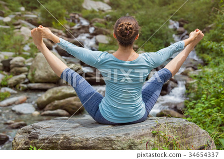 Woman doing Ashtanga Vinyasa Yoga asana outdoors 34654337