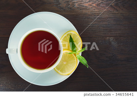 White cup of tea with cinnamon sticks, lemon, mint White cup of tea with cinnamon sticks, lemon, mint 34655641
