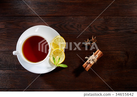 White cup of tea with cinnamon sticks, lemon, mint White cup of tea with cinnamon sticks, lemon, mint 34655642