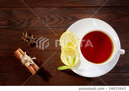 White cup of tea with cinnamon sticks, lemon, mint White cup of tea with cinnamon sticks, lemon, mint 34655643