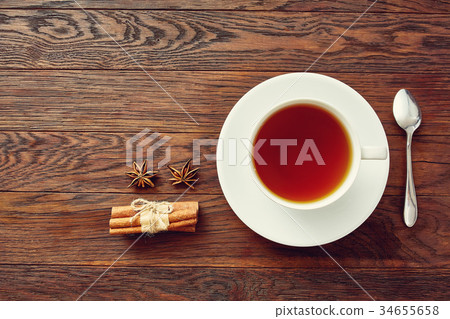 A cup of tea on a rustic wooden board, top view A cup of tea on a rustic wooden board, top view 34655658