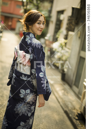 A woman in a yukata walking in the city 34656868