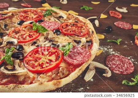 Closeup of pizza with salami, tomatoes and olives Closeup of pizza with salami, tomatoes and olives 34656925
