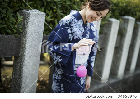 Woman in yukata enjoying water balloons 34656970