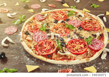 Closeup of pizza with salami, tomatoes and olives Closeup of pizza with salami, tomatoes and olives 34656971
