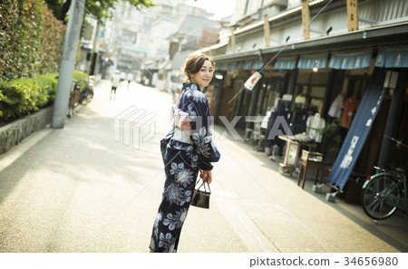 A woman in a yukata walking in the city 34656980