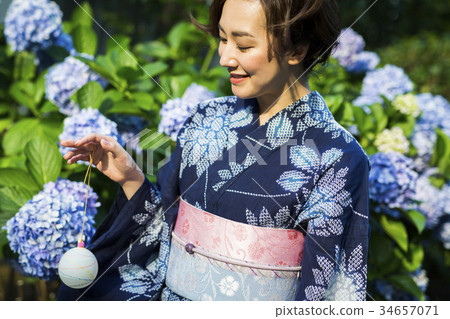 Woman in yukata enjoying water balloons Woman in yukata enjoying water balloons 34657071