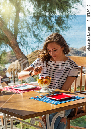 Young woman at the beach cafe Young woman at the beach cafe 34658042