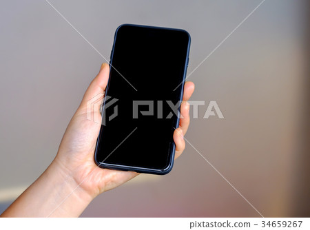 Woman holding smart phone with blured background. 34659267