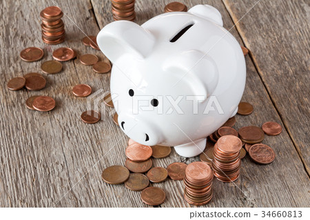 Piggy bank and pile of coins Piggy bank and pile of coins 34660813