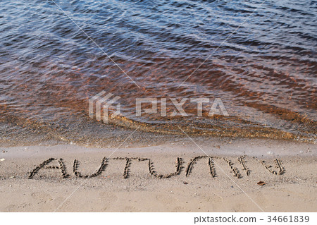 Word autumn written on sand background 34661839