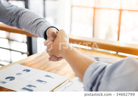 Two confident business man shaking hands during a meeting in the Two confident business man shaking hands during a meeting in the 34662799