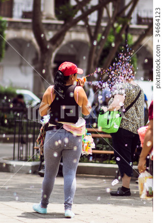 Girl making soap bubbles on market in Guatemala 34664123