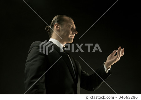 The attractive man in black suit on dark 34665280