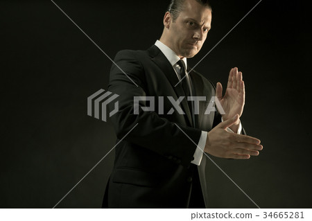 The attractive man in black suit on dark 34665281