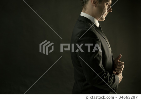 The attractive man in black suit on dark 34665297