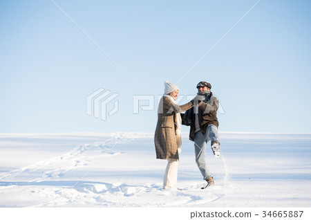 Beautiful senior couple on a walk in sunny winter Beautiful senior couple on a walk in sunny winter 34665887