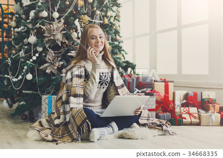 Young woman shopping online in cozy christmas Young woman shopping online in cozy christmas 34668335