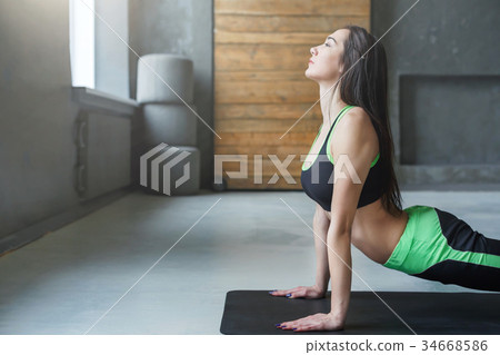 Young woman in yoga class, dog pose asana 34668586