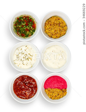 Variety of sauces in white bowls isolated 34669229