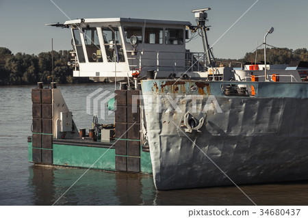 Pusher boat stands moored near cargo ship 34680437
