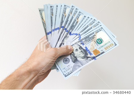 Fan of One Hundred Dollars notes in male hand Fan of One Hundred Dollars notes in male hand 34680440