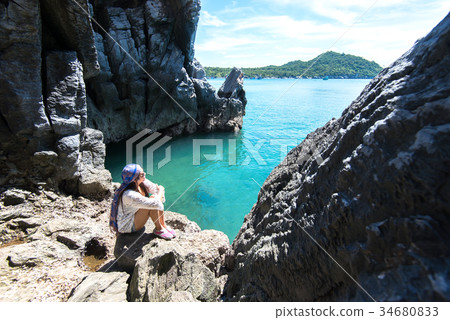 Travel women in a cave near the sea 34680833