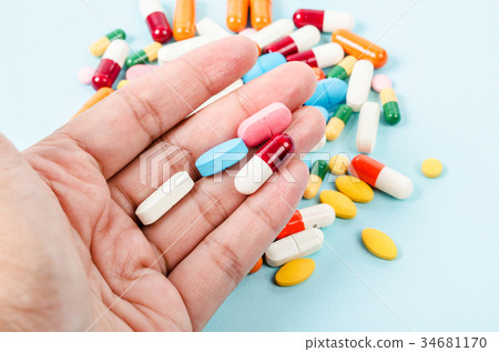 Colorful pills in hand on pill background. Colorful pills in hand on pill background. 34681170