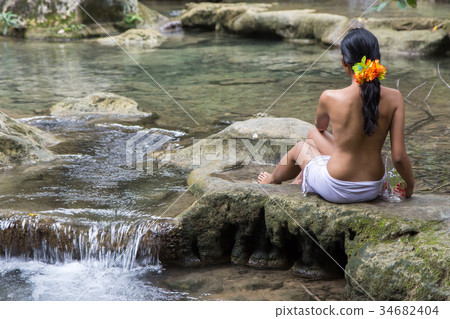 woman with jar sitting by the creek 34682404