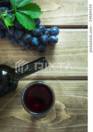 Open bottle of wine with a glass, grape on board. Open bottle of wine with a glass, grape on board. 34684434