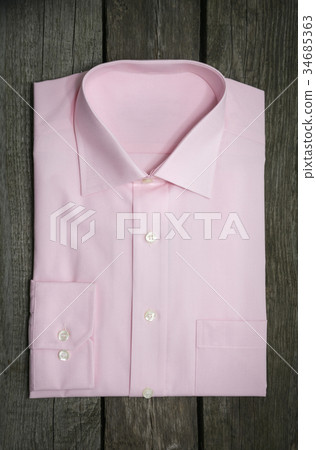 Pink shirt and mobile on wooden background Pink shirt and mobile on wooden background 34685363