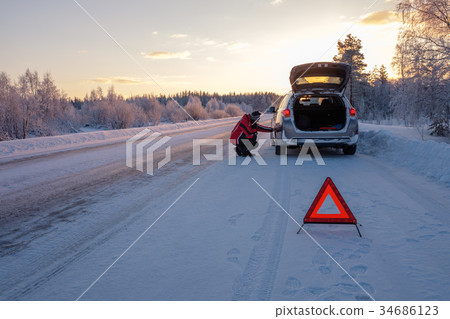 Broken on a snowy winter road 34686123