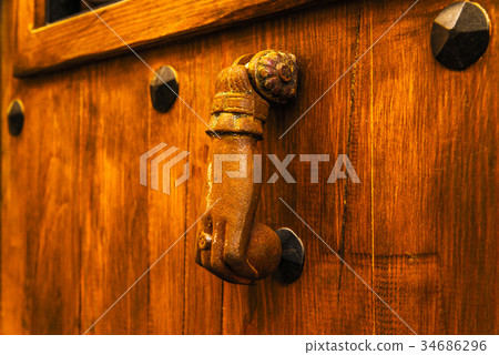 Door with brass knocker in the shape of a hand Door with brass knocker in the shape of a hand 34686296