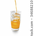 orange soda pouring into glass with ice. 34688210