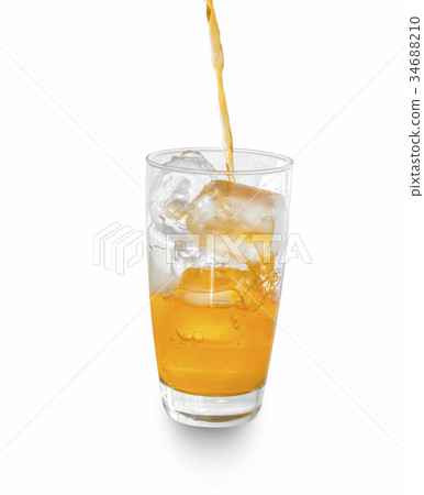 orange soda pouring into glass with ice. 34688210