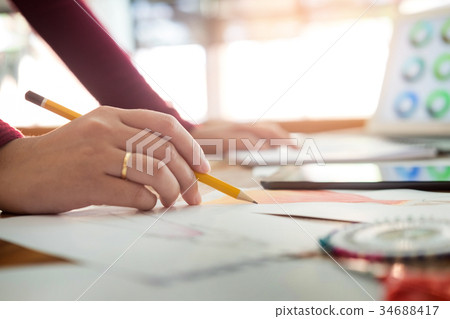 young women working as fashion designer drawing sketches for clo young women working as fashion designer drawing sketches for clo 34688417