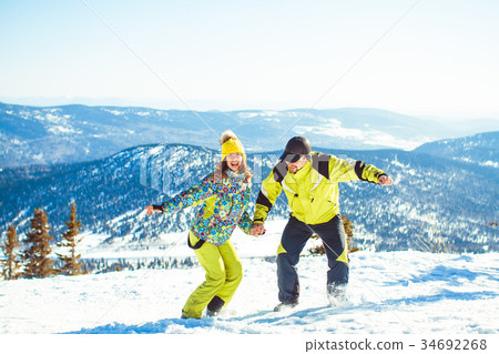 Couple jumping in the winter in the mountains Couple jumping in the winter in the mountains 34692268