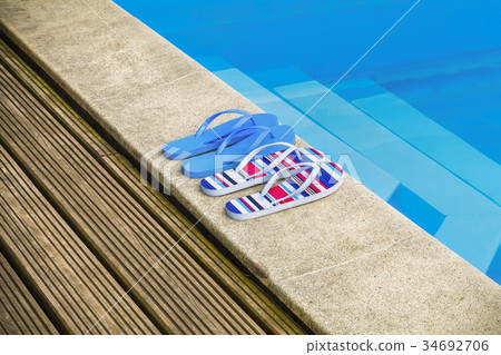 Two pairs of flip flops by the pool Two pairs of flip flops by the pool 34692706